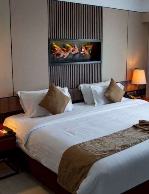 A cozy hotel room with a large bed, stylish lighting, and elegant decor creates a welcoming atmosphere.